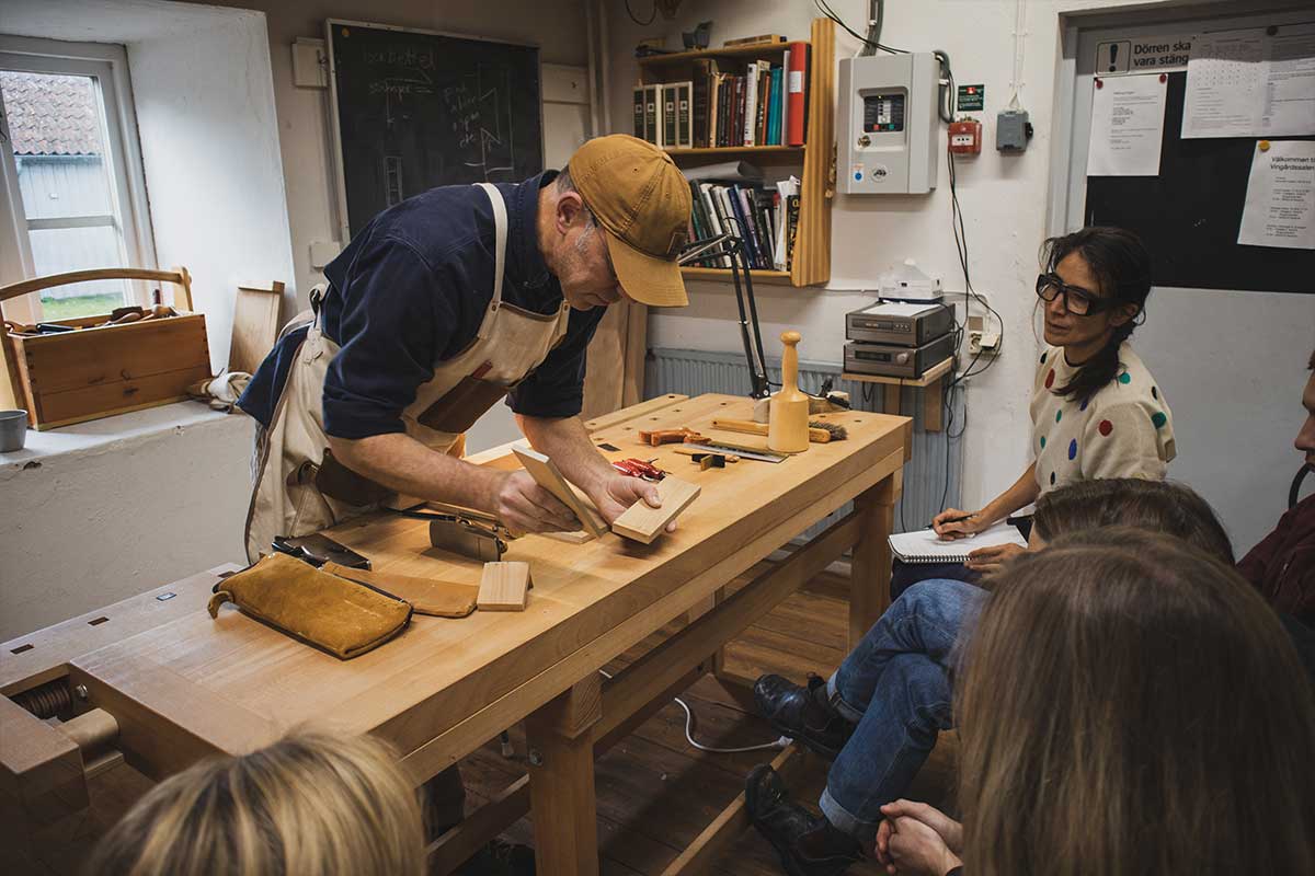 Kaj står vid sin hyvelbänk Sjöbergs Original 1900 och undervisar sina elever på Capellagården.